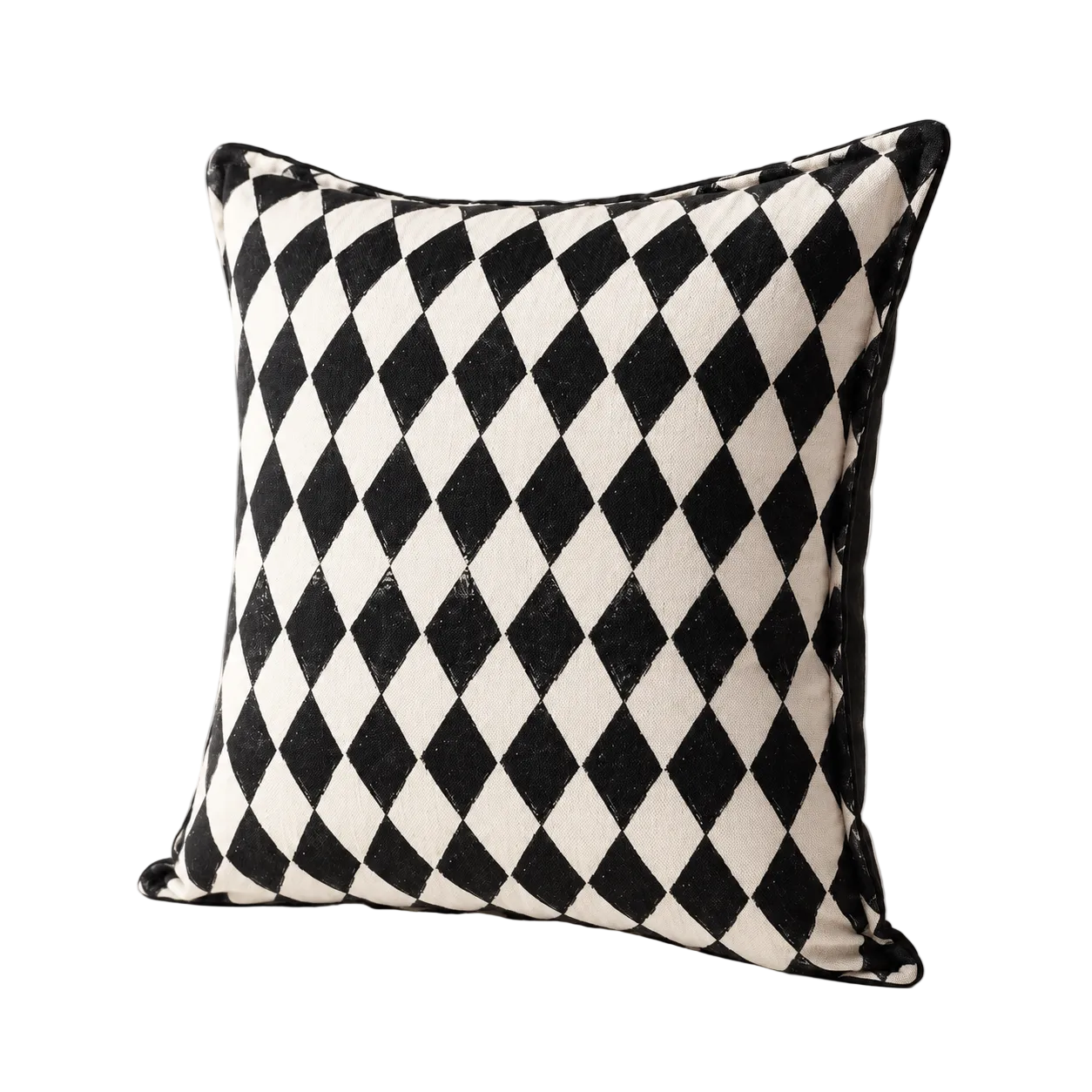 Cojín decorativo con rombos arlequín en blanco y negro, vista en ángulo semi-lateral