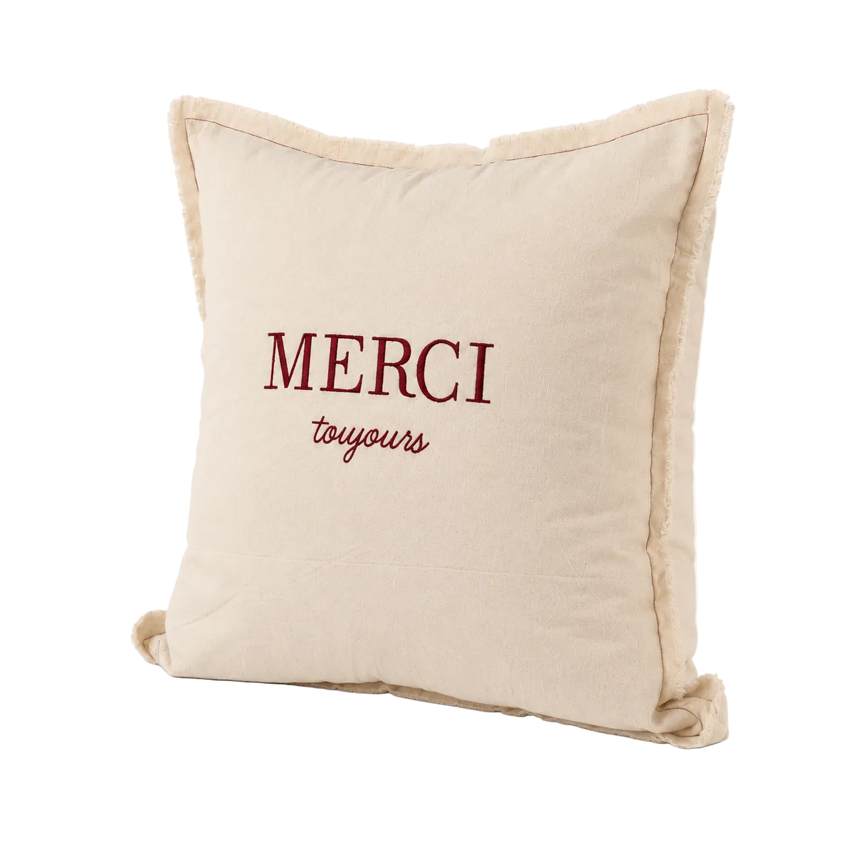 Cojín decorativo de tela con frase Merci Toujours bordada en burdeo sobre fondo crudo, vista en ángulo semi-lateral